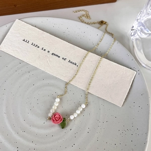 French luxury rose necklace with pink pendant and white pearls on a ceramic dish