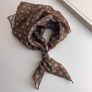 Detail of vintage brown silk scarf featuring blue floral patterns and orange dots