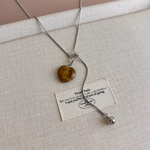 Detail of tiger eye heart pendant on silver snake chain with adjustable Y-shaped pull design