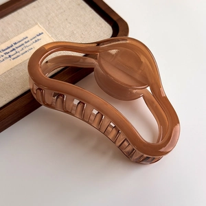 Detailed close-up of translucent amber resin shark hair claw clip with elegant hollow design