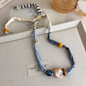 Detail of fabric patchwork necklace with colorful beads and artistic textile patterns