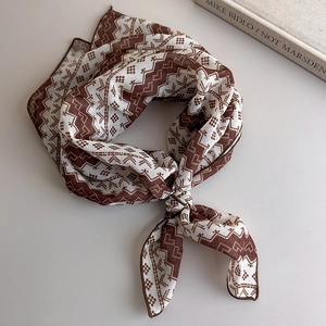 Detail of retro geometric wave patterns on brown silk scarf with professional stitched edges