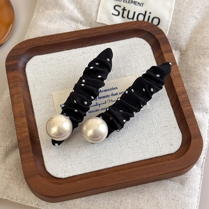 French retro black polka dot duckbill hair clips with elegant pearls on a wooden tray