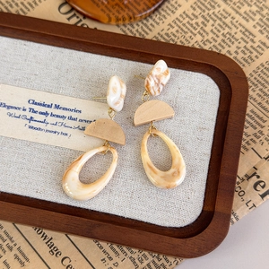 Detail view of vintage marble resin and wood teardrop earrings in a wooden jewelry box