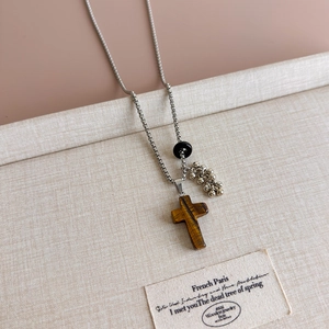 Detailed view of Tiger's Eye cross pendant on a vintage silver box chain necklace