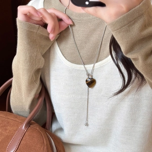 Tiger eye stone heart necklace with adjustable silver chain on beige knit sweater