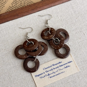 Details von Vintage-Boho-Ohrringen aus Holzreifen mit natürlicher Textur auf Leinen