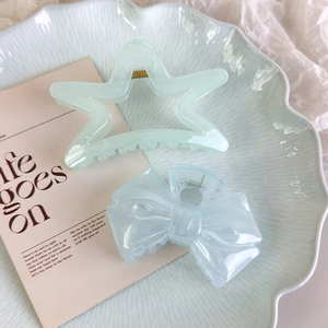 Détail de la pince à cheveux étoile vert menthe et nœud bleu clair en résine de haute qualité