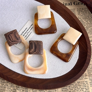 French vintage resin square earrings with tortoiseshell and wood patterns on newspaper
