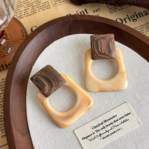 Detail of vintage square resin earrings with amber marble texture on linen base
