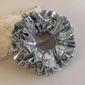 Dettaglio dell'elastico per capelli in argento metallizzato su base in pietra