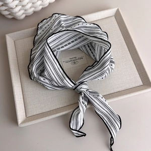 Detail of French style black and white striped scarf with refined stitched edges in tray