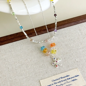 Close-up of colorful crystal star pendant and beads on a silver chain necklace