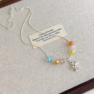 Macro detail of colorful crystal beads and a multicolor gemstone snowflake pendant necklace