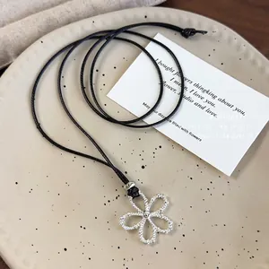 Silver hollow flower pendant necklace on a long black adjustable cord for women