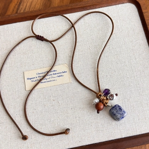 Vue détaillée du pendentif ethnique avec pierre bleue naturelle et perles en bois mixtes