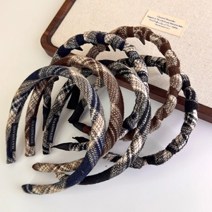 Detail of plaid fabric headbands with non-slip teeth and handmade labels in a tray