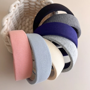 Ribbed knit padded headbands in six pastel colors on a woven basket for hair styling