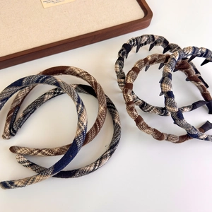 Detail of vintage plaid fabric headbands with anti-slip inner teeth and braided texture