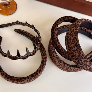 Detailed macro shot of leopard print fabric headbands with visible handmade label text