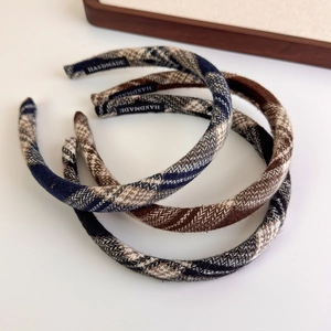 Detail of three handmade plaid fabric headbands with elegant scottish check patterns