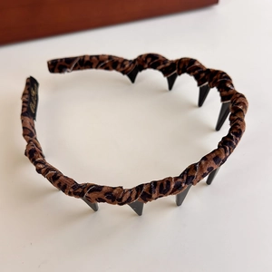 Detail of leopard print velvet headband featuring inner non-slip comb for secure grip