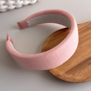 Detail of pink knitted sponge headband with ribbed texture and non-slip inner lining