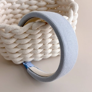 Detail showing light blue-grey ribbed fabric texture on a wide padded headband