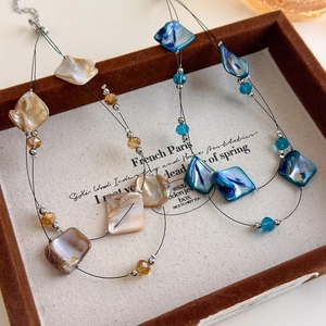 Double-layered seashell necklace in cream yellow and deep blue with faceted glass beads