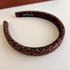Detail of handmade leopard print headband with inner handmade label and velvet texture