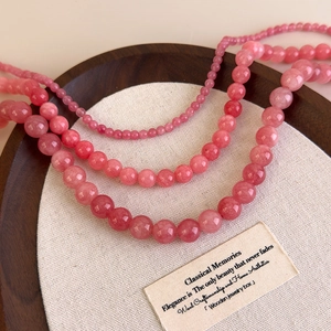 Détail de colliers en perles de quartz rose naturel en trois tailles de perles