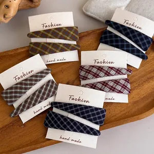 Five sets of vintage plaid fabric hair clips in blue, red, brown, and green on display cards