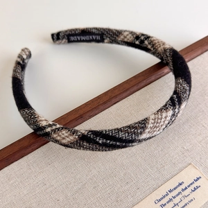 Detailed view of handmade checkered fabric headband with premium texture and woven label