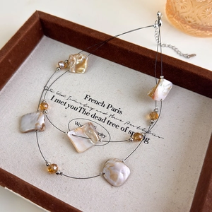 Detail of double-layer shell necklace with square mother of pearl and amber crystal beads