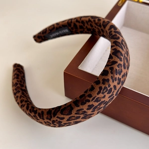 Detailed macro view of leopard print padded headband with handmade interior woven label