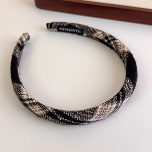 Detail of handmade woven plaid headband featuring premium texture and inner brand label