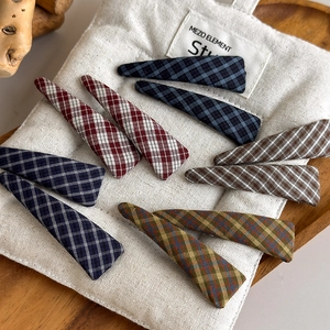Classic checkered fabric snap hair clips set in various colors on a soft textile surface