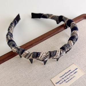 Detail view of plaid fabric headband featuring non-slip teeth and vintage college style