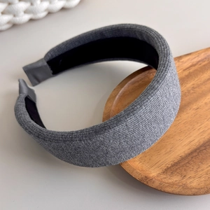 Close-up of grey knitted fabric texture and sponge padding on a wide fashion headband