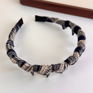 Close-up of brown plaid fabric headband featuring non-slip teeth and vintage tweed texture