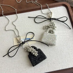 Detail of sparkling rhinestone handbag pendants in black and silver with bead chains