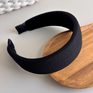 Detail of black ribbed knit sponge headband with textured fabric and soft padded edges