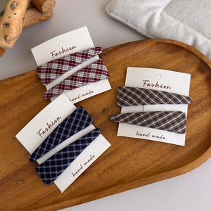 Detailed macro view of plaid fabric hair clips set in red, blue and brown tones