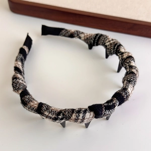 Detail view of the non-slip inner teeth and vintage plaid fabric texture of the headband