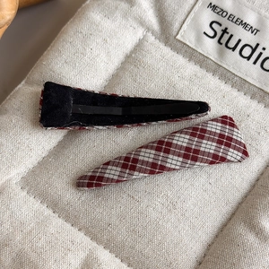 Macro view of vintage red and white plaid hair clips with metal duckbill structure