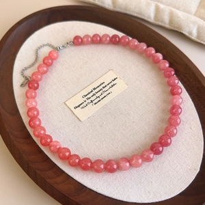 Détail macro du collier en perles de pierre rose naturelle avec chaîne d'extension argentée