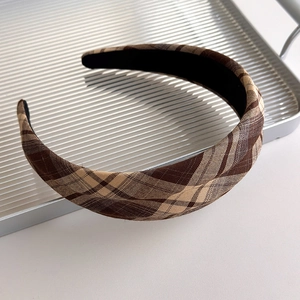 Macro detail of French vintage plaid headband with non-slip lining on silver tray