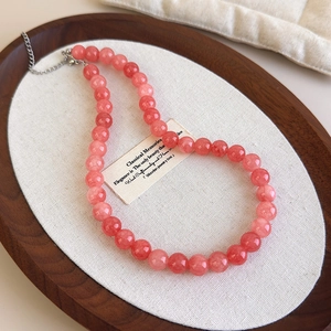 Détail du collier de perles en pierre naturelle rose avec fermoir en argent sur plateau