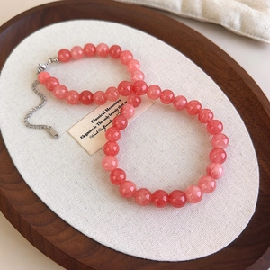 Détail du collier de perles en pierre naturelle rose avec fermoir argent sur lin