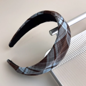 Detail showing the brown and light blue plaid fabric texture of this wide headband